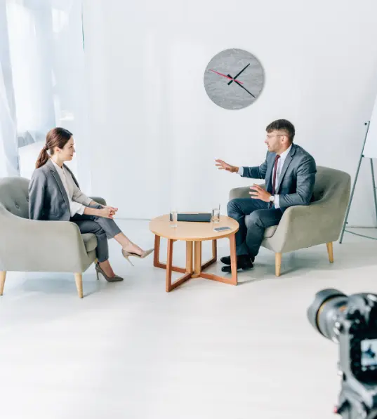 Best Thought Leadership Video Creation Company in Ramnagar There are two artists sitting in chairs and having a conversation, which was shot with a camera.